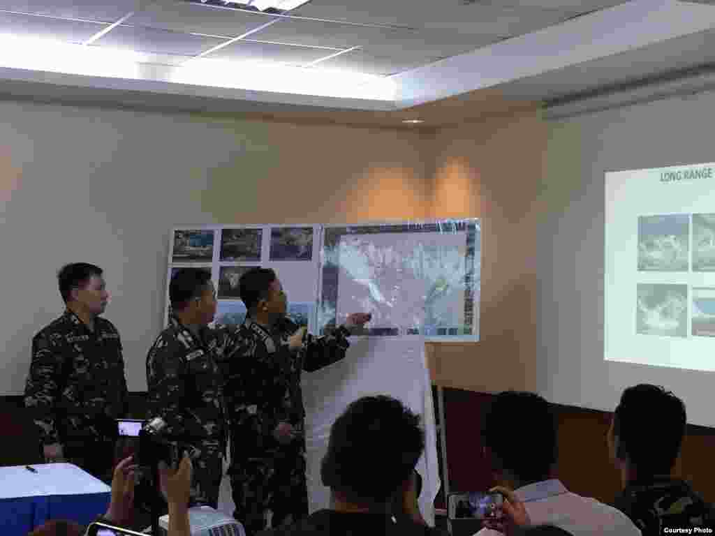 Philippine Armed Forces Chief of Staff General Gregorio Pio Catapang uses a laser pointer to show reclamation work on a reef the Philippines claims, Armed Forces General Headquarters, Quezon City, Philippines, April 20, 2015. (Simone Orendain/VOA)