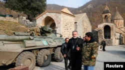 The monastery's abbot Father Hovhannes walks past a military vehicle of the Russian peacekeeping forces at the Dadivank, an Armenian Apostolic Church monastery, Nov. 15, 2020.