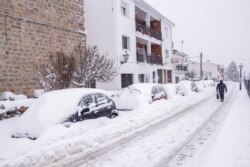 A man walks under a heavy snowfall in Bustarviejo, on the outskirts of Madrid, Spain, Jan. 9, 2021. A persistent blizzard has blanketed large parts of Spain with 50-year-record levels of snow.