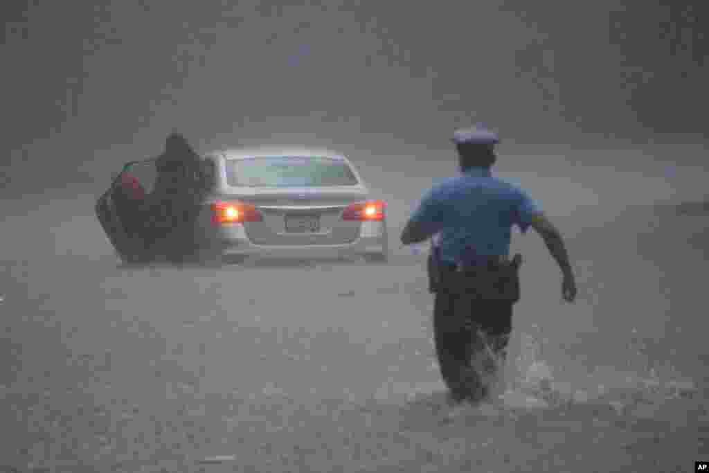 허리케인 이사이아스의 영향으로 폭우가 내린 미국 필라델피아에서 경찰이 차가 물에 잠긴 주민을 구출하고 있다.