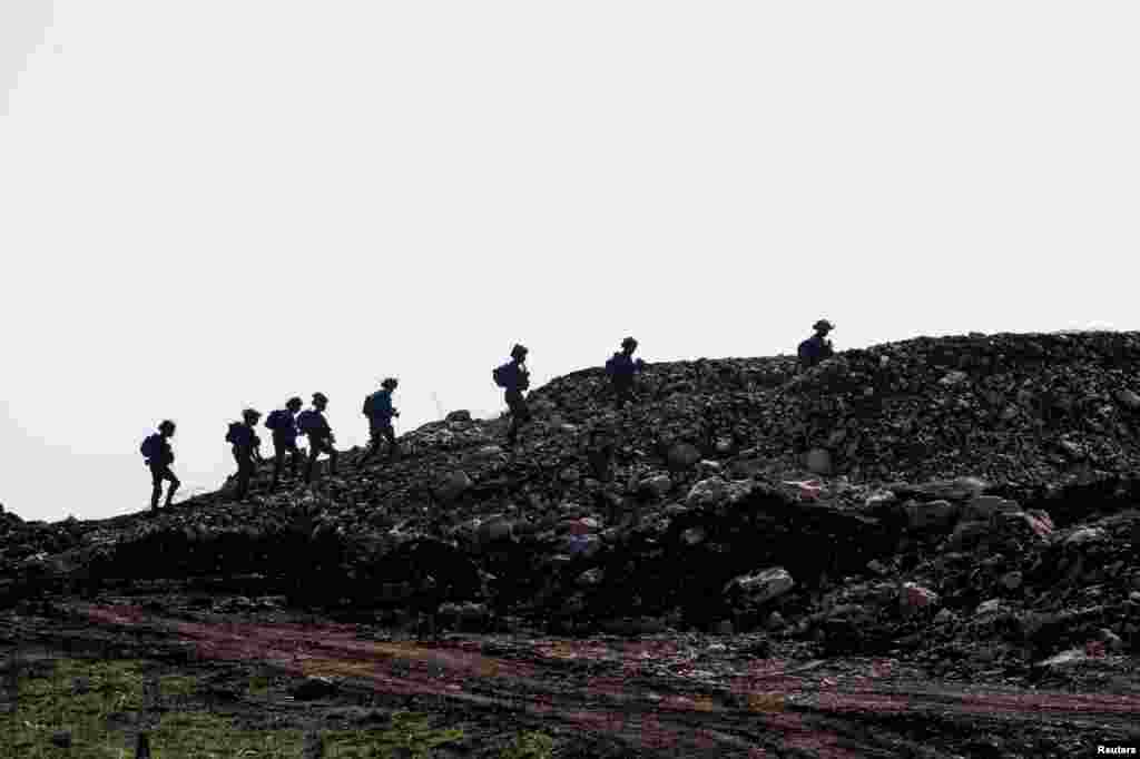 Israeli soldiers walk in the buffer zone, near the Israel-Lebanon border, as seen from Israel.