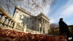 FILE — In this Nov. 19, 2010 file photo, a woman walks past the front entrance to Marble House, a Gilded Age mansion in Newport, Rhode Island.