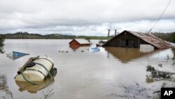 Un granero y equipo agrícola se ven sumergidos en las aguas de la inundación del río Russian en Forestville, California, el miércoles 27 de febrero de 2019.