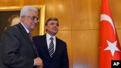 Turkey's President Abdullah Gul (background) and Palestinian President Mahmoud Abbas (L) walk, at Ataturk Airport in Istanbul, July 18, 2014.