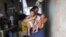 Jaqueline (L), 25, holds her five-month-old twins, Laura (R) and Lucas at their house in Santos, Sao Paulo state, Brazil, April 20, 2016. 