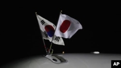 South Korean (L) and Japanese national flags fly on an airplane carrying Japanese Prime Minister Yoshihiko Noda upon his arrival at a military airport in Seongnam, near Seoul, October 18, 2011.