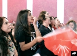 People react while watching a live broadcast of the Turkish referendum results during an event organised by the Turkish Republican People's Party in Berlin, Germany, Sunday April 16, 2017.