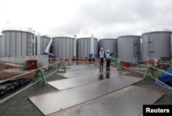 Workers are seen near storage tanks for radioactive water at Tokyo Electric Power Co's (TEPCO) tsunami-crippled Fukushima Daiichi nuclear power plant in Okuma town, Fukushima prefecture, Japan January 15, 2020. Picture taken January 15, 2020. (REUTERS/Aaron Sheldrick)