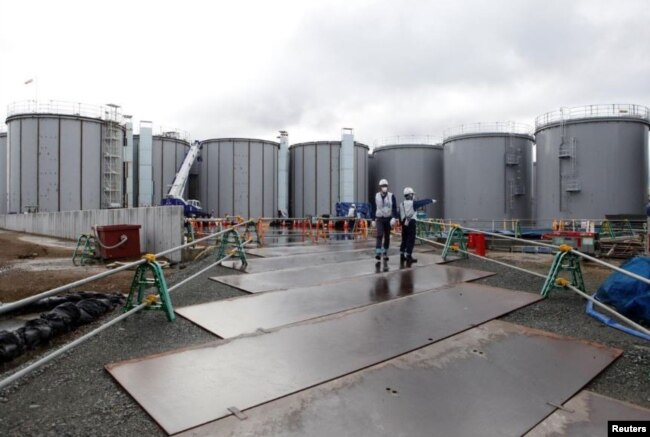 Workers are seen near storage tanks for radioactive water at Tokyo Electric Power Co's (TEPCO) tsunami-crippled Fukushima Daiichi nuclear power plant in Okuma town, Fukushima prefecture, Japan January 15, 2020. Picture taken January 15, 2020. (REUTERS/Aaron Sheldrick)