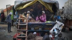 Indian farmers gather together in the back of their tractor trailer early morning as they protest to abolish new farming laws they say will result in exploitation by corporations.