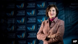 In this March 2014 image released by the National Dialogue Preparatory Commission, Salwa Bugaighis, lawyer and rights activist, poses for a photograph during a meeting in Tripoli, Libya