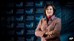 In this March 2014 image released by the National Dialogue Preparatory Commission, Salwa Bugaighis, lawyer and rights activist, poses for a photograph during a meeting in Tripoli, Libya