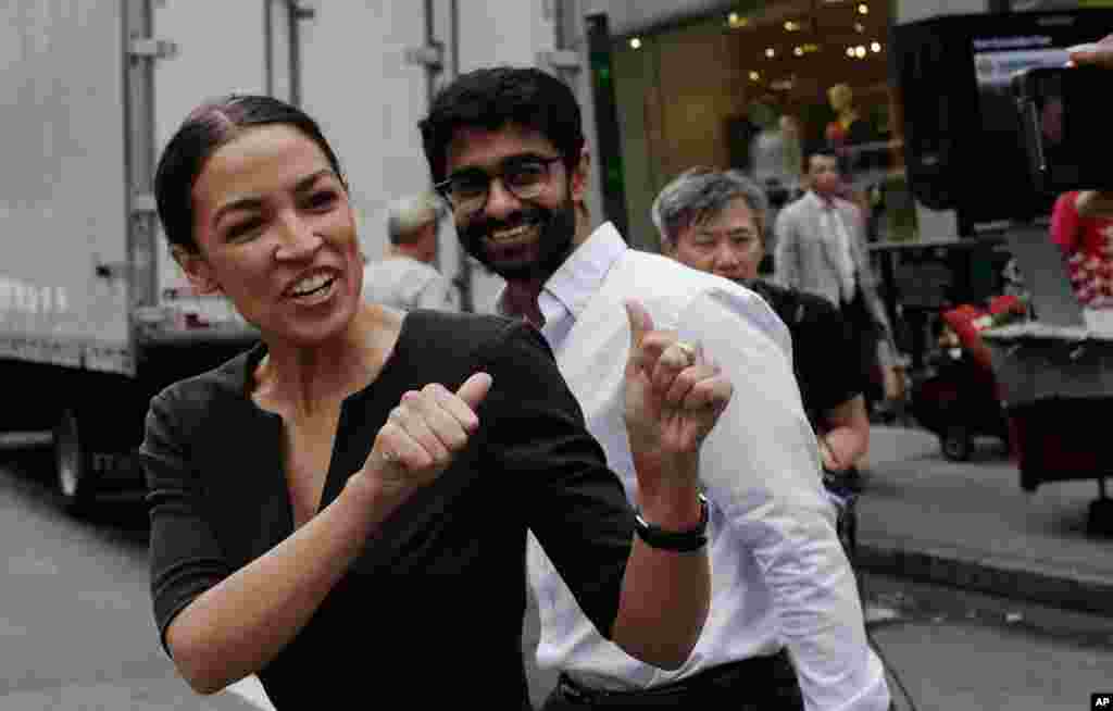 Alexandria Ocasio-Cortez, the winner of a Democratic Congressional primary in New York, greets a passerby in New York, the morning after she upset U.S. Rep. Joe Crowley in Tuesday's primary election.