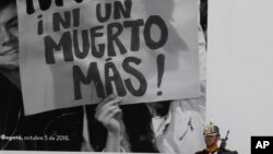 Foto de archivo de un soldado colombiano parado junto a un cartel en el que piden ni un muerto más. Decenas de indígenas colombianos han sido asesinados en años reciente junto con líderes sociales tras la firma del acuerdo de paz de 2016.