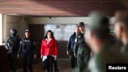 La exsenadora colombiana Aida Merlano camina escoltada hacia una audiencia tras su captura en Venezuela. 