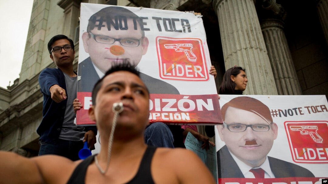 Demonstran di depan poster calon presiden Manuel Baldizon, menuntut reformasi pemilu di Guatemala City, Sabtu, 5 September 2015.