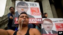 Demonstran di depan poster calon presiden Manuel Baldizon, menuntut reformasi pemilu di Guatemala City, Sabtu, 5 September 2015.