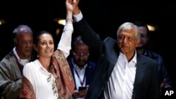 Presidential candidate Andres Manuel Lopez Obrador, of the MORENA party, right, and Mexico City mayoral candidate Claudia Sheinbaum hold their closing campaign rally at Azteca stadium in Mexico City, Wednesday, June 27, 2018. 