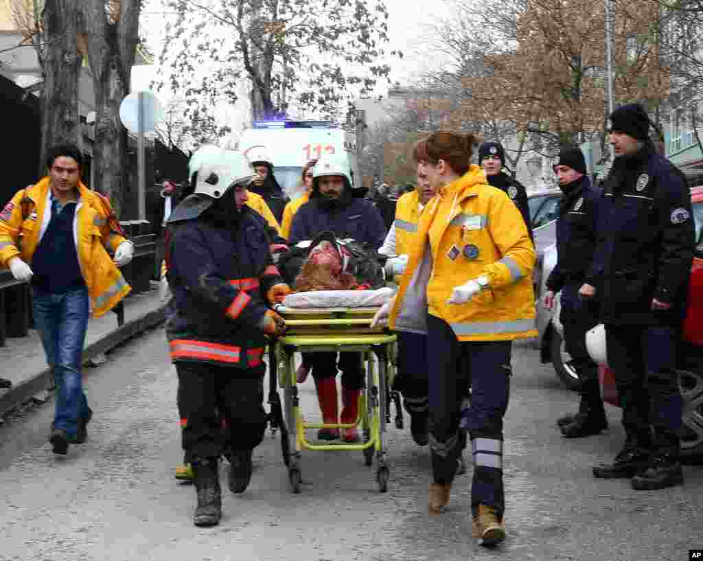 G&ouml;revliler patlamada yaralanan bir kişiyi ambulansa hastaneye taşıdı. 