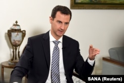 FILE - Syria's President Bashar al-Assad speaks to journalist.