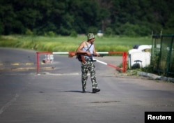 An armed pro-Russian separatist guards a border post abandoned by Ukrainian border guards at Chervonopartyzansk along the Ukraine-Russia border, June 7 2014.