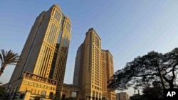 People walk by Sawiris Towers, seven months after president Hosni Mubarak was ousted, and Egypt's business community becomes vocal in its pleas for the interim government to detail how it plans to revive confidence in the economy, in Cairo, Egypt, Septemb