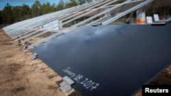 The first of the eventual 375,000 solar panels sits on a rack after a ceremonial initial installation ceremony at Eglin Air Force Base, Florida, Jan. 18, 2017.