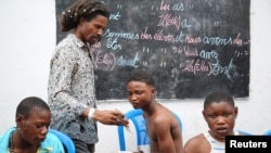 Cedrick Tshimbalanga, 32, the founder of Mokili Na Poche cultural centre, uses his phone while talking to homeless teenagers during a lunch at the cultural center in Kinshasa, Democratic Republic of Congo September 5, 2023. (REUTERS/Justin Makangara)