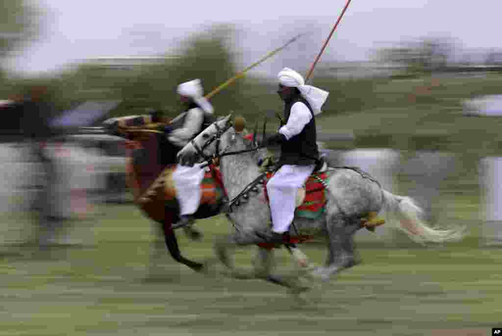 Riders proceed to their targets during competition organized by the Pakistan Tent Pegging Association in Islamabad. In tent pegging, a horseman gallops and uses a sword or a lance to pierce, pick up, and carry away a wooden peg.