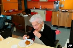 In this photo taken on April 6, 2020, 103-year-old Ada Zanusso, eats her meal at the nursing home "Maria Grazia" in Lessona, northern Italy, after recovering from Covid-19 infection. (Residenza Maria Grazia Lessona via AP Photo)