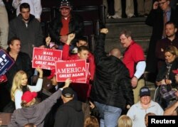 A protester walks out of a rally that is part of President-elect Donald Trump's and Vice President-elect Mike Pence's "USA Thank You Tour 2016" in Cincinnati, Ohio, Dec. 1, 2016.