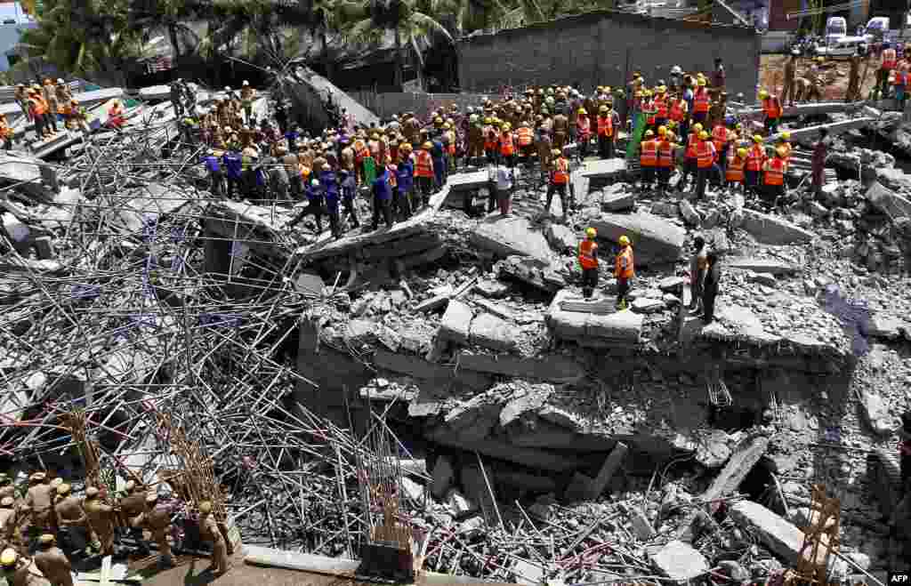 Indian rescue workers look for survivors in the rubble of a collapsed multi-storeyed building in Porur town, situated on the outskirts of Chennai. At least nine people were killed and dozens feared trapped after an 11-storey residential block crumbled, officials said.
