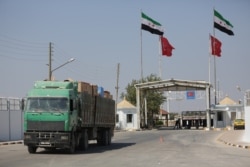 FILE - A Syrian truck carrying Turkish goods enters from Bab al-Salam point near the city of Azaz, Syria, Aug. 20, 2018.