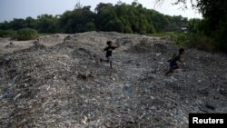 Kids play on piles of imported plastic waste in Mojokerto, East Java province, Indonesia, June 19, 2019.