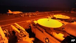 FILE- In this file photo released by the U.S. Navy on Sept. 23, 2014, A-18C Hornet, attached to Strike Fighter Squadron (VFA) 87, prepares to launch from the flight deck of the aircraft carrier USS George H.W. Bush.