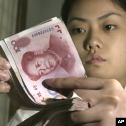 A Chinese bank worker displays Chinese yuan at a bank in a Beijing (File Photo)