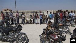 ဆီးရီးယားနိုင်ငံ၊ အာဇတ်စ်မြို့မှာ ပေါင်မုန့်ရဖို့ တန်းစီစောင့်ဆိုင်းနေတဲ့ ပြည်သူများ။ (သြဂတ် ၁၅၊ ၂၀၁၂။)