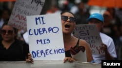 FILE - Women participate in a demonstration to ask for decriminalization of abortion in San Salvador, El Salvador, Sept. 28, 2017. The writing on the placard reads, "My body, my rights." 