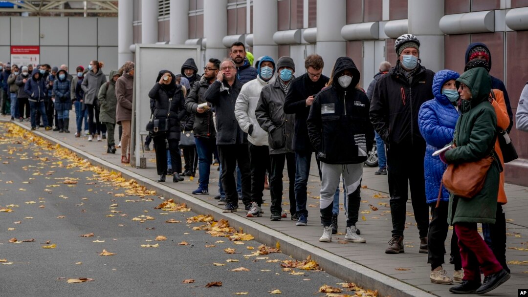 People queue in front of a COVID vaccination center in Frankfurt, Germany, Nov. 22, 2021.
