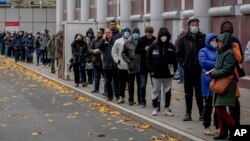 People queue in front of a COVID vaccination center in Frankfurt, Germany, Nov. 22, 2021.