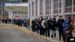 People queue in front of the vaccination center in Frankfurt, Germany, Nov. 22, 2021 to get their booster shot or first vaccination. 