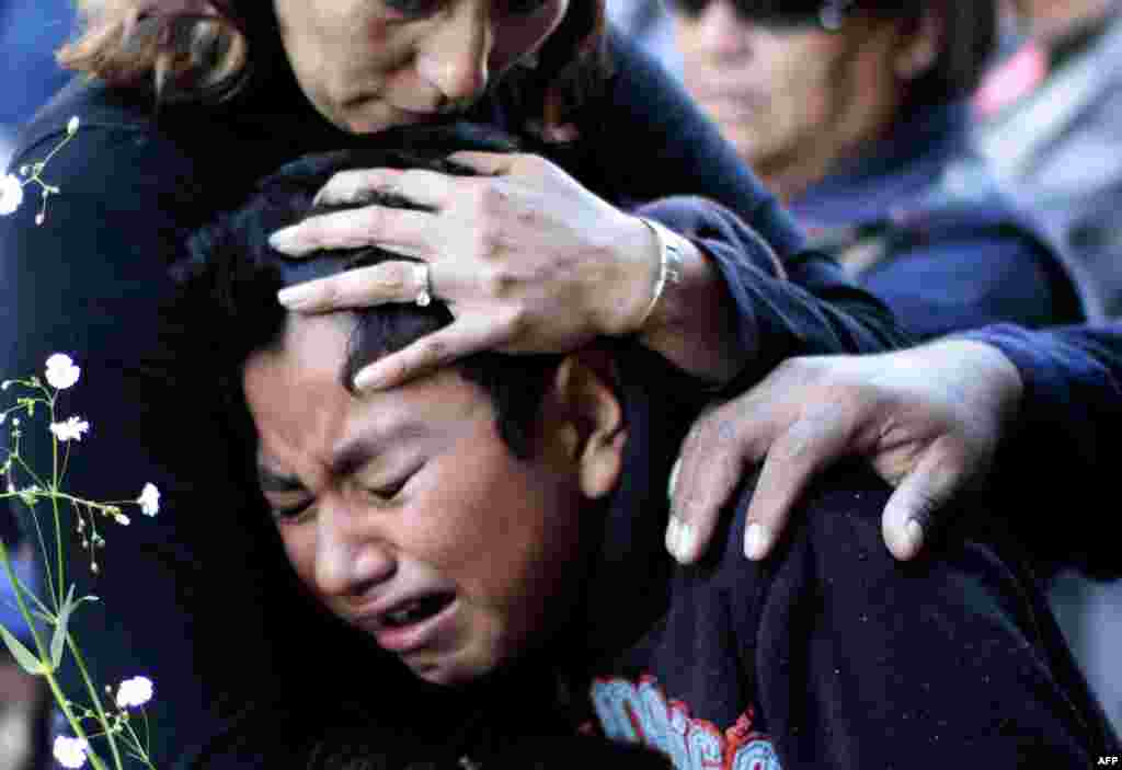 People cry during a mass for the victims of the fireworks market explosion in Tultepec, Mexico state.