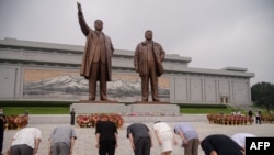 지난 2013년 12월 북한 김정일 국방위원장 사망 2주기를 맞아 평양 김일성 광장의 대형 초상화 아래 참배객들이 모여있다. 