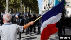 A protester holds a French flag as he takes part in a demonstration on Act 45 (the 45th consecutive national protest on Saturday) of the yellow vests movement in Paris, France, Sept. 21, 2019. 