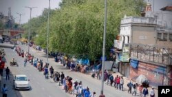 People line up to board trains outside New Delhi railway station in New Delhi, India, May 12, 2020 as India is reopening some of its colossal rail network after seven-week strict lockdown amid an increase in coronavirus infections.