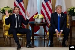 President Donald Trump, right, listens as French President Emmanuel Macron speaks at their meeting at Winfield House during the NATO summit, in London, Dec. 3, 2019.