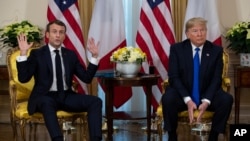 President Donald Trump, right, listens as French President Emmanuel Macron speaks at their meeting at Winfield House during the NATO summit, in London, Dec. 3, 2019.