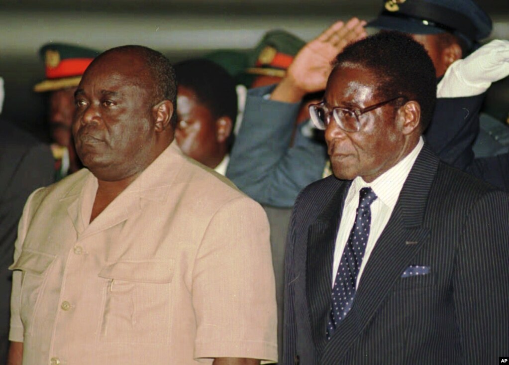 President Laurent Kabila of the Democratic Republic of Congo, left, is met at the Harare International Airport Sunday evening June 1, 1997 by Zimbabwean President Robert Mugabe. (AP Photo)