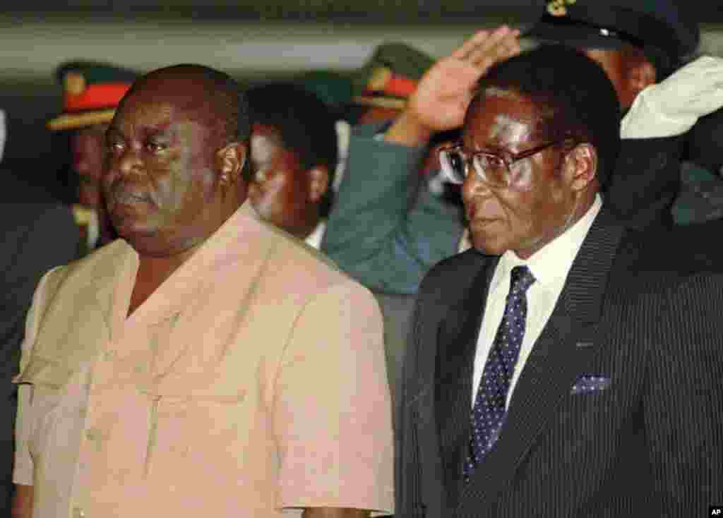 Le président congolais Laurent Kabila, à gauche, est accueilli par le président zimbabwéen Robert Mugabe à l&#39;aéroport international d&#39;Harare, le 1er juin 1997.