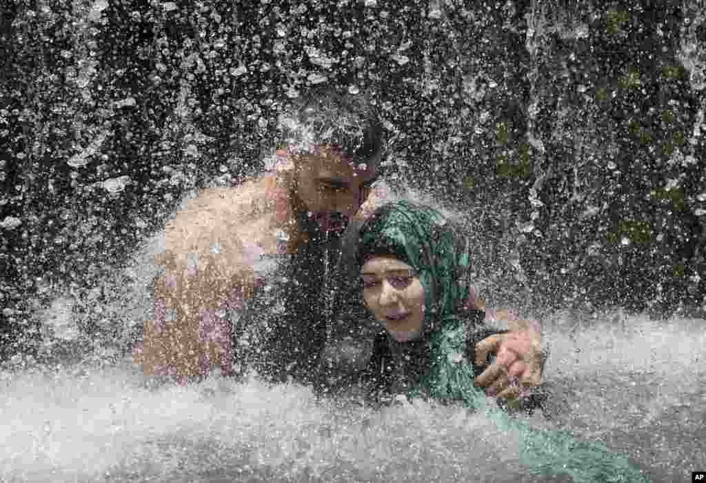 Israeli Arabs stand under a waterfall during the Eid al-Fitr holiday at the Gan HaShlosha national park near the northern Israeli town of Beit Shean. Eid al-Fitr marks the end of the Muslim holy fasting month of Ramadan.